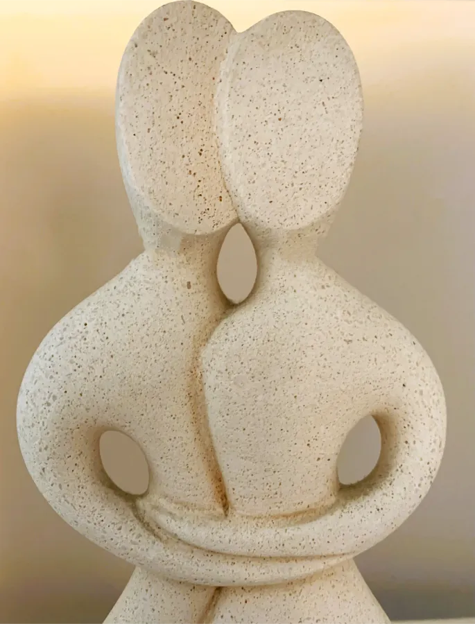 Abstrakte Steinskulptur eines eng verbundenen Paares als Symbol für Paartherapie